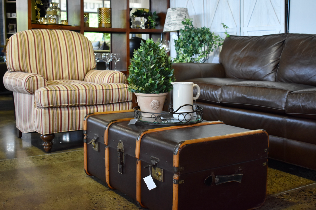 Classic chair, brown leather sofa, and trunk turned into coffee table