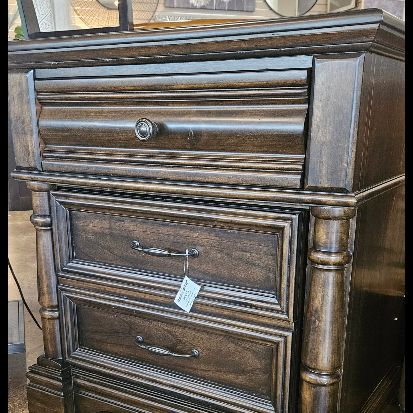 A dark brown wooden chest of drawers with a single drawer and two cabinet doors.